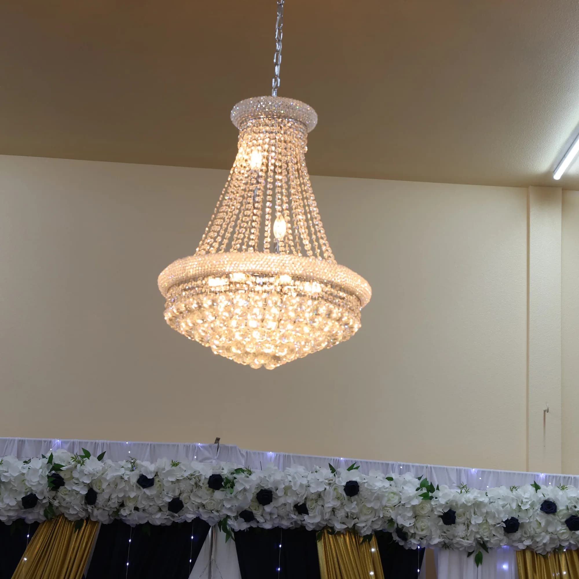 Crystal chandelier over a floral garland backdrop in the Grand Ballroom